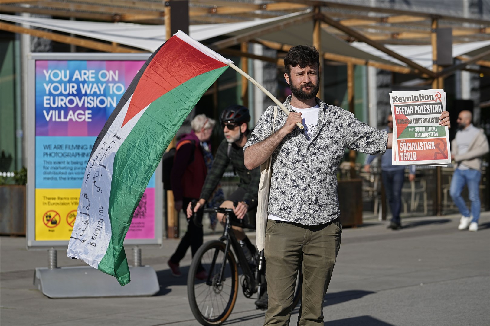 A man holds a Palestinian flag as he protests ahead of the first semi-final at the Eurovision Song Contest in Malmo, Sweden (Martin Meissner/AP)