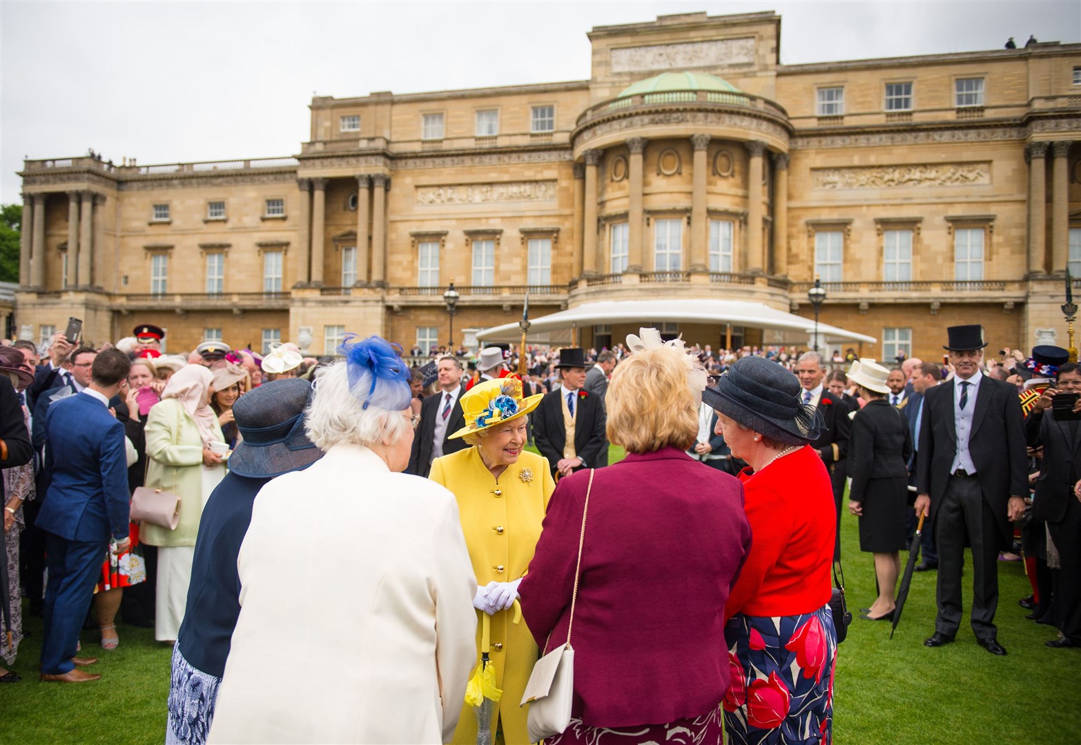 The Queen greeting guests during a garden party at Buckingham Palace (PA)