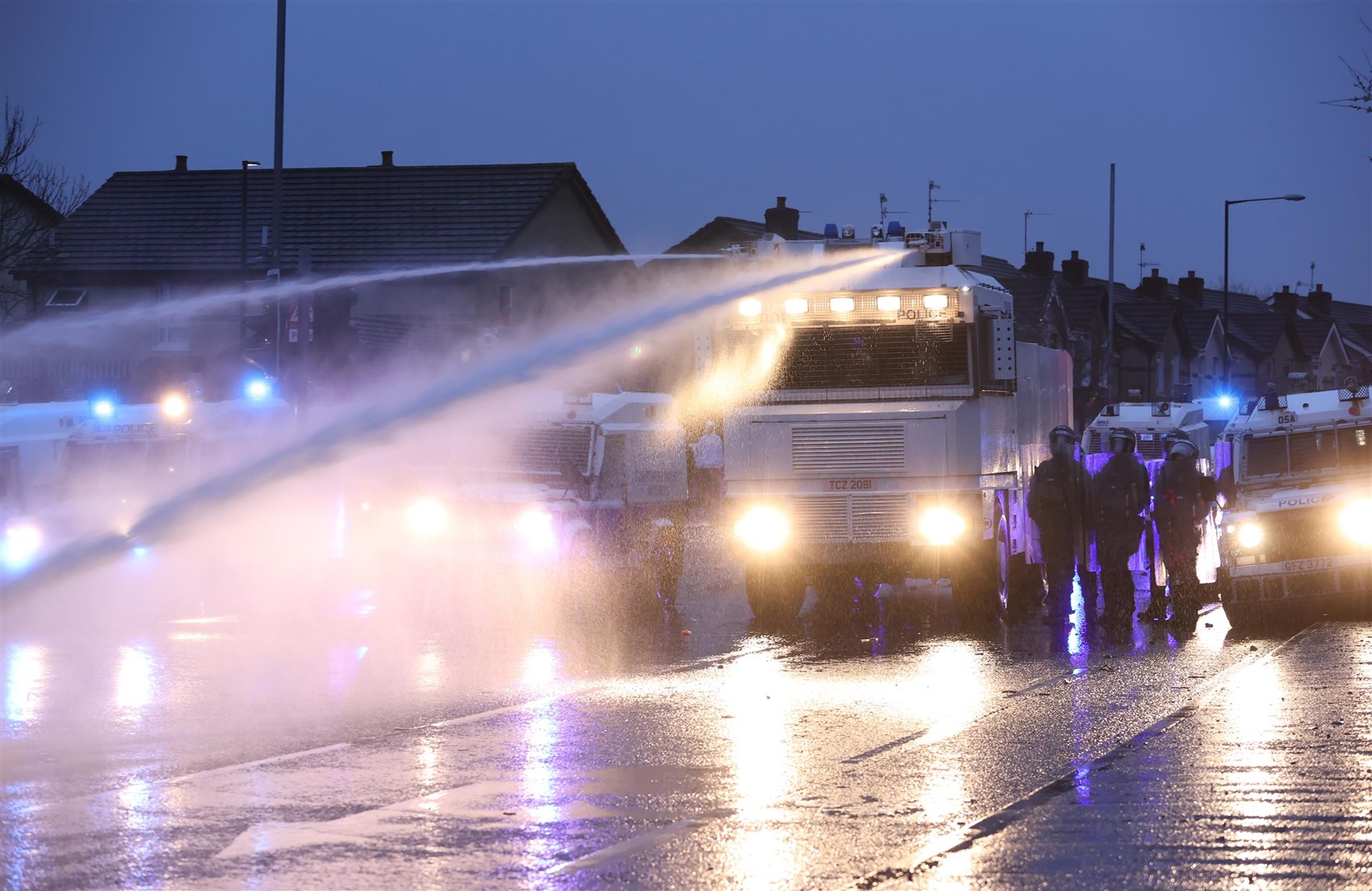The PSNI use a water cannon on the Springfield road, during further unrest in Belfast (Liam McBurney/PA)