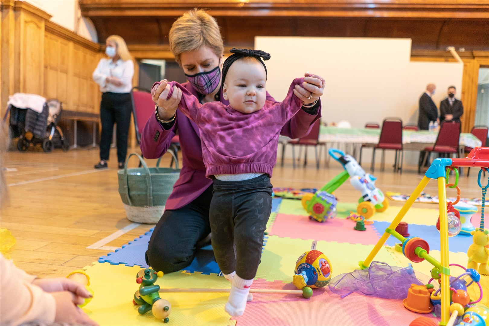 Wearing a tartan mask to play with nine-month-old Amelia Mackinnon during a visit at Govan Help in Glasgow in 2022 (Peter Summers/PA)