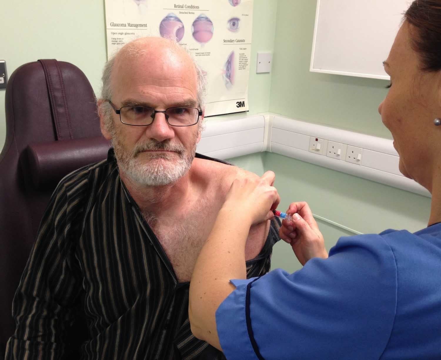 NHS Highland employee director Adam Palmer receiving his flu vaccine from vaccinator Jackie Preston..