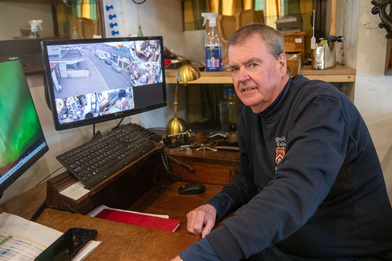 Bill Powrie with his CCTV camera feed. He has CCTV set up in the store and says the theft was caught on video (not pictured here). Picture: Callum Mackay