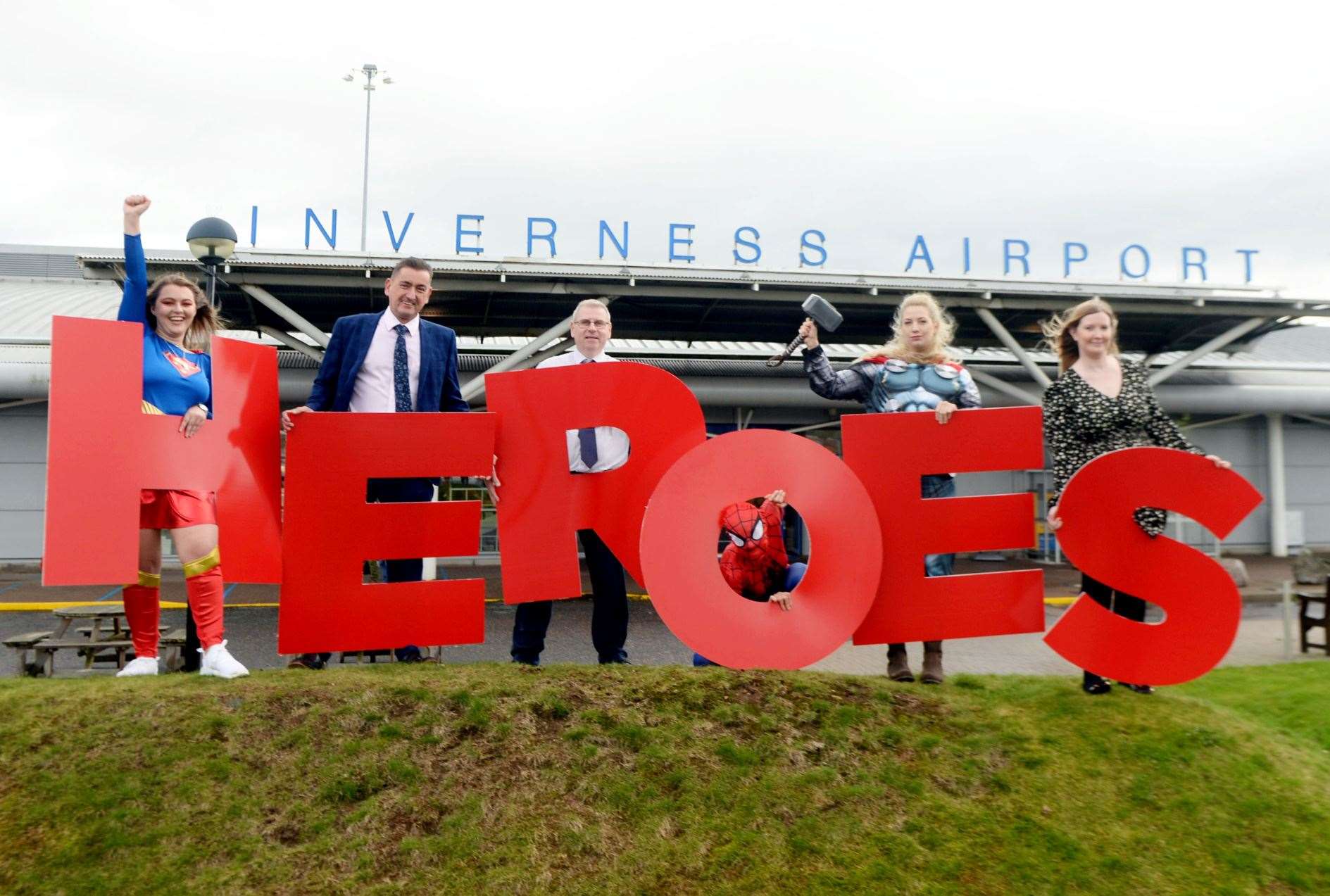 Graeme Bell, Inverness Airport general manager, Davie Geddes, terminal operations manager and Cheryl Campbell, airport services manager, with super friends, launched Highland Heroes 2022. Picture: James Mackenzie