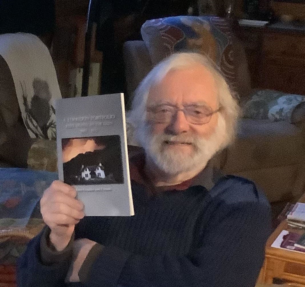 Dave Goulder holds up a copy of his new book.
