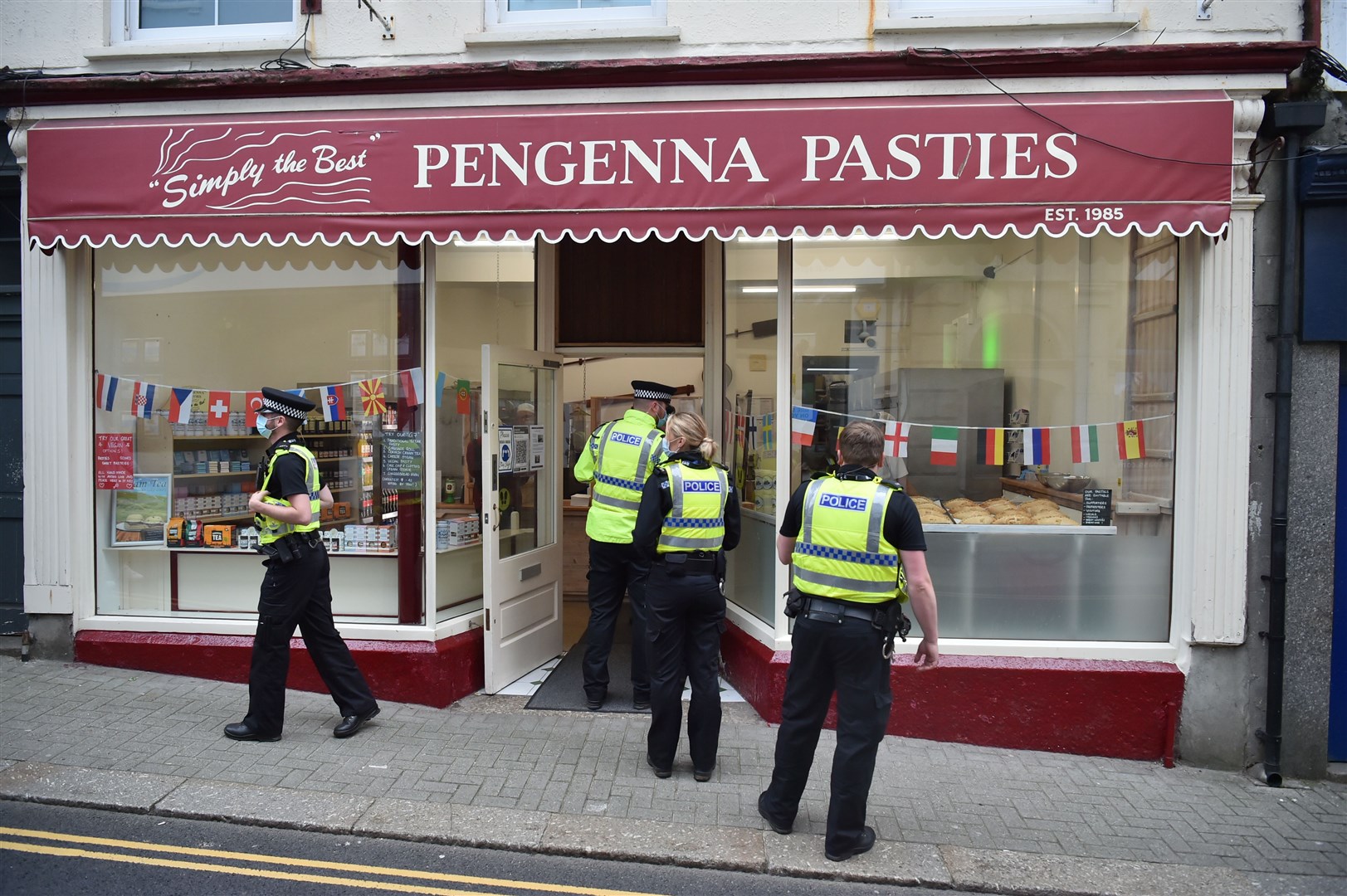 Police officers queuing for breakfast outside Pengenna Pasties in St Ives during the G7 summit in Cornwall (Ben Birchall/PA)