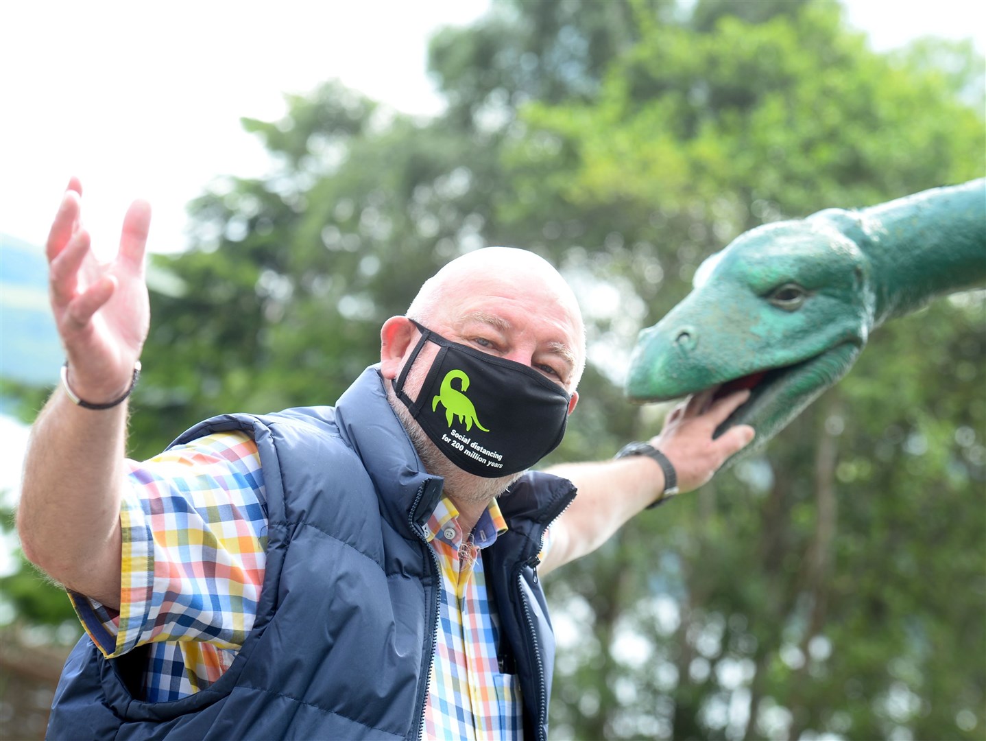 Willie Cameron models one of the Nessie facemasks on the banks of Loch Ness.