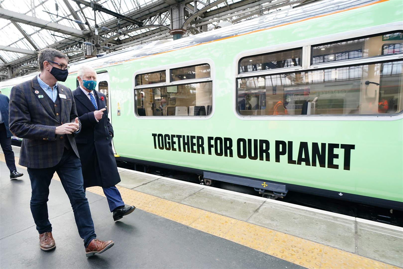 The Prince of Wales and Martin Fisher of Network Rail alongside a hydrogen powered train as part of Network Rail’s Green Trains @ COP26 event (Jane Barlow/PA)