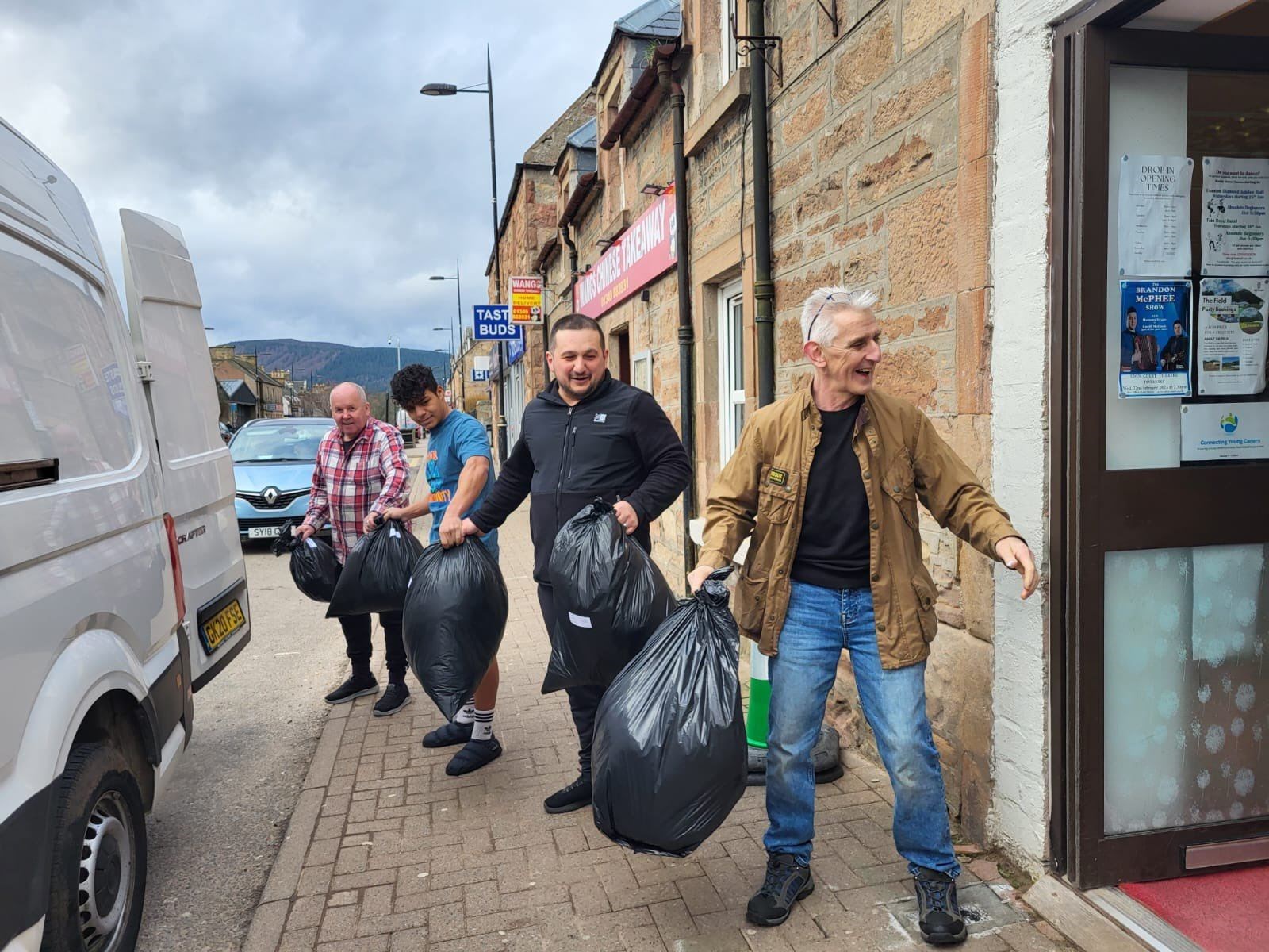 Gordon Robertson (from left), Shadi Ali, Serhat Yavuz and John Douglas form a human chain to load goods donated at The Place for the earthquake relief.
