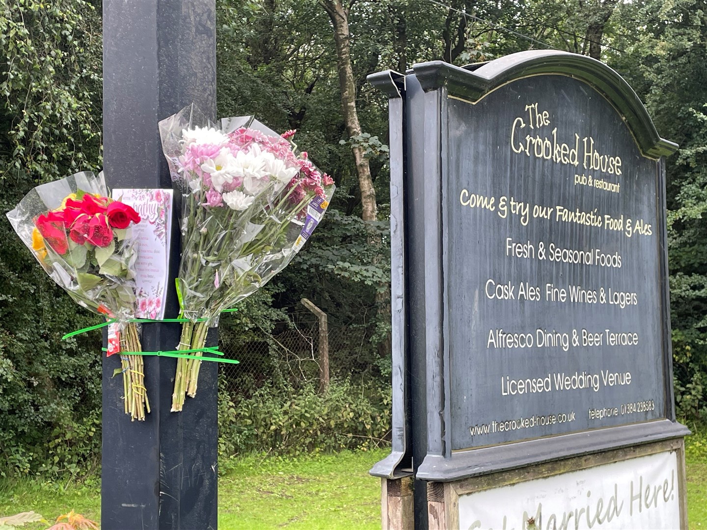Flowers and a sympathy card left on signage near the pub (Matthew Cooper/PA)