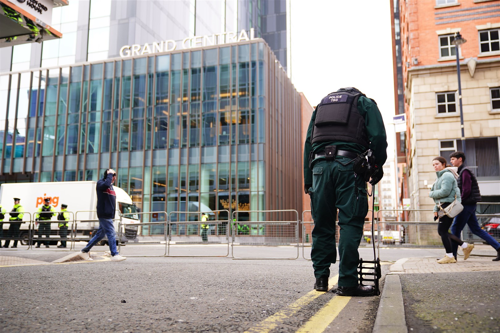 A police officer from the TSG demonstrates a security inspection of a drain, close to the Grand Central Hotel, Belfast (PA)