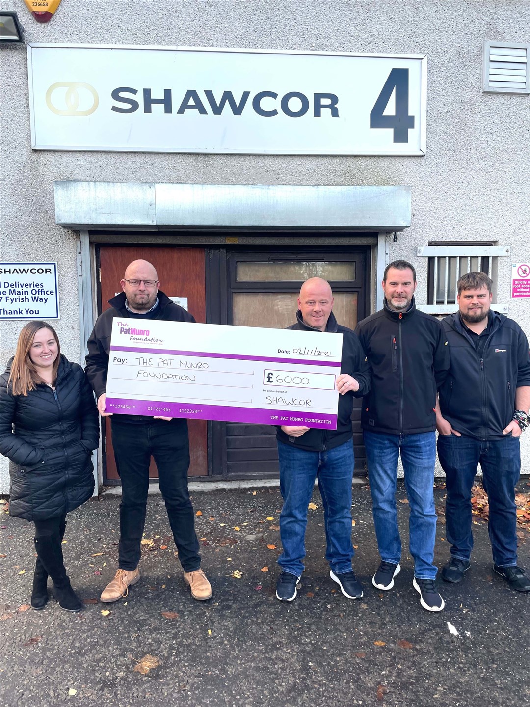 John Howden, Darren Gilliland and other SPS Offshore staff present the cheque to Lauren Munro.