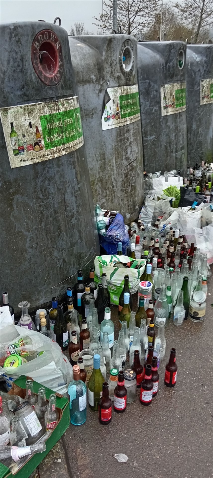 Piles of glass bottles were spotted next to the full bottle banks at the Dores Road Tesco supermarket on Sunday morning.