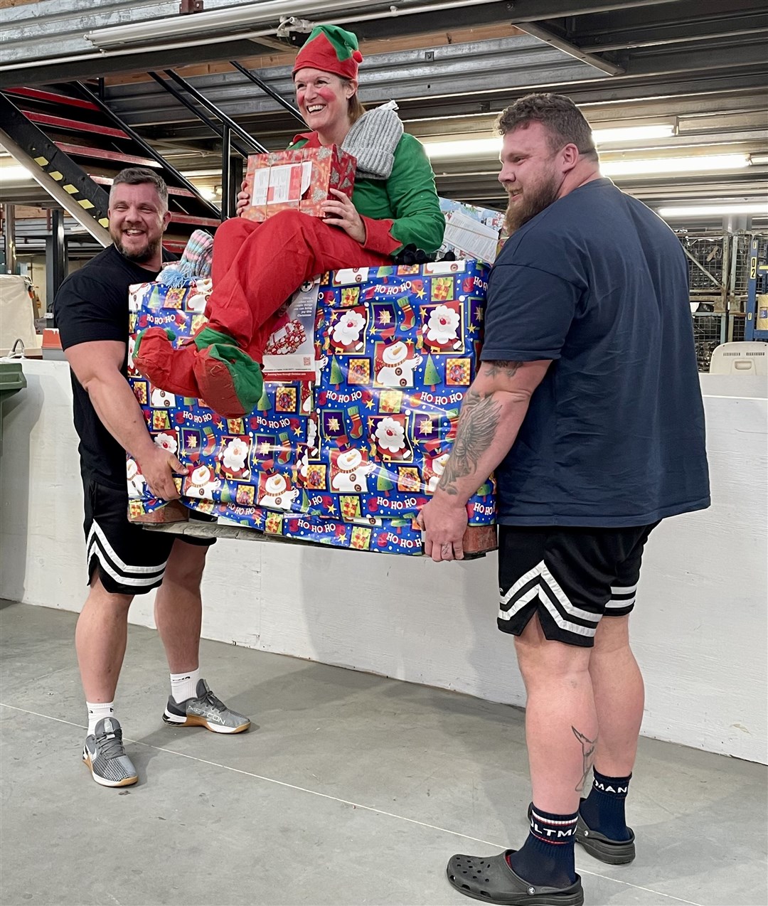 Elf and safety: Tom and Luke Stoltman raise a pallet of shoeboxes with Shona Mackenzie, one of Blythswood’s sorting team, seated atop.