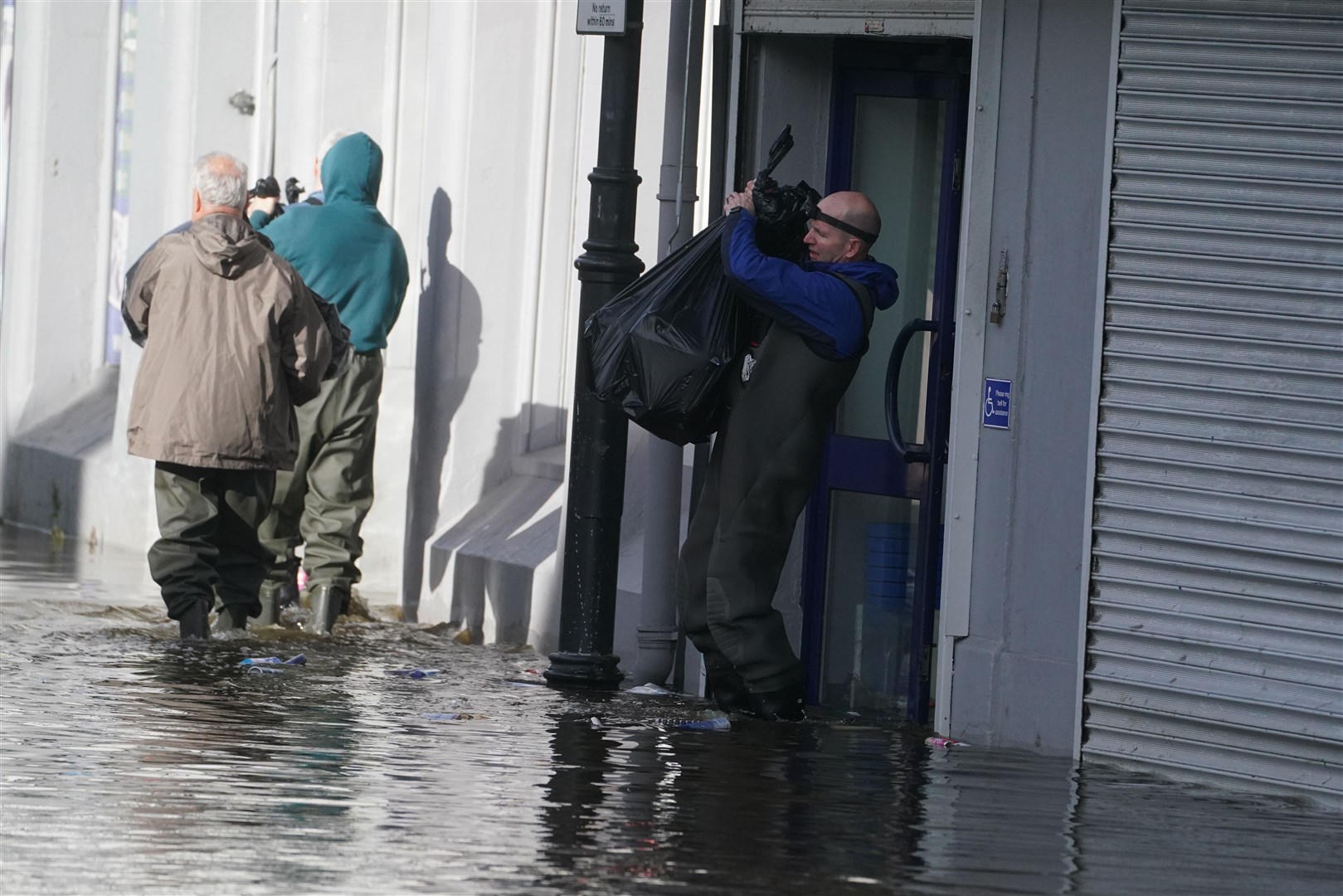 People clear out damaged shops in Sugar Island, Newry Town (Brian Lawless/PA)