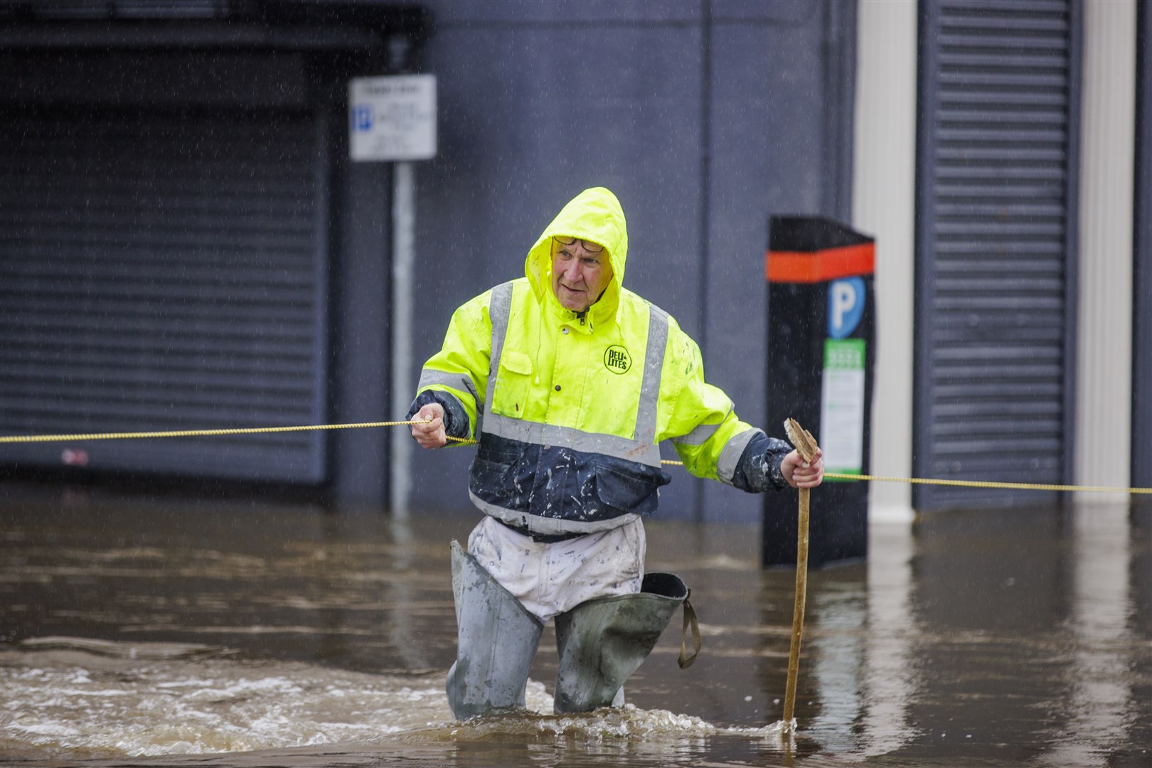 Gerry Peers uses a guide rope to cross flood water on Bank Parade in Newry (Liam McBurney/PA)