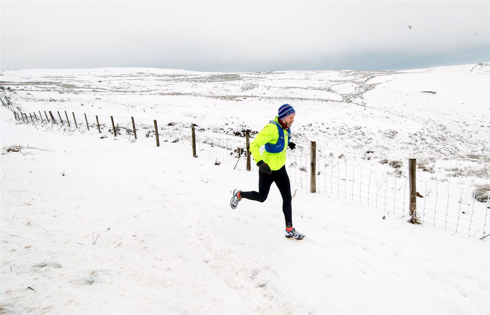 A man runs in heavy snow near Ladmanlow in Derbyshire (Danny Lawson/PA)