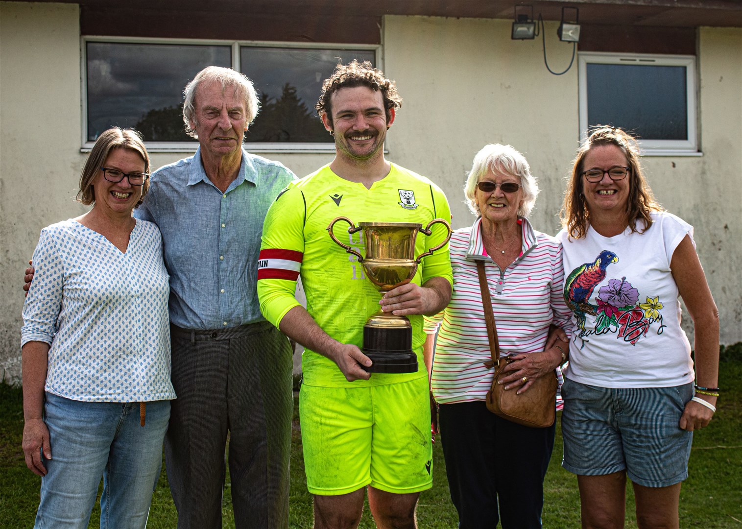 Family connected to Kenny 'Raigie' Macleod with Lochbroom team captain William Godding. Photo: Niall Harkiss