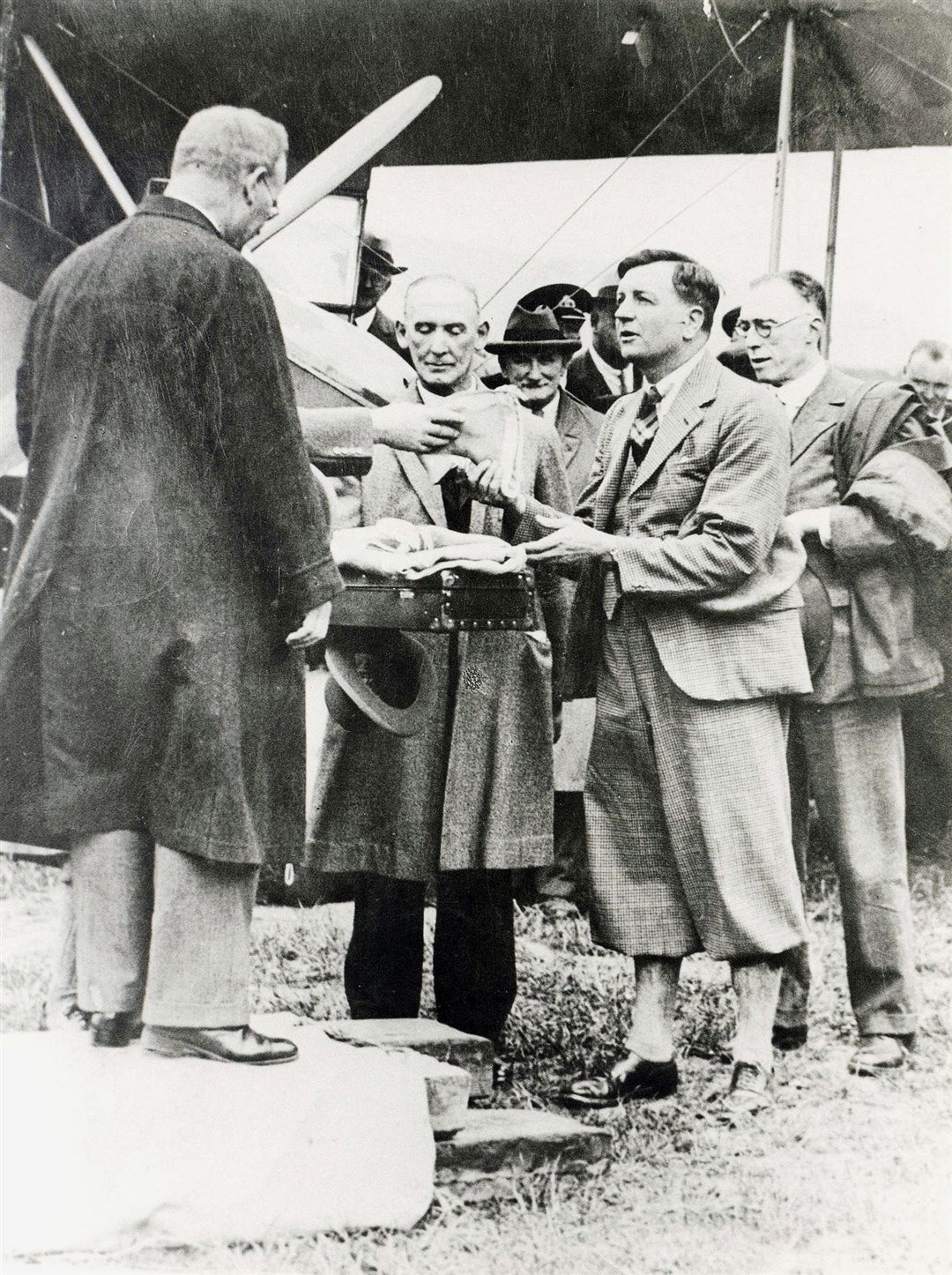 Captain Fresson accepts a special pennant from Sir Frederick Wilson, Britain’s Postmaster General, before the first scheduled air mail flight from Inverness to Orkney in May, 1934. In centre is AJ Campbell, head postmaster, Inverness. Picture courtesy of Am Baile.