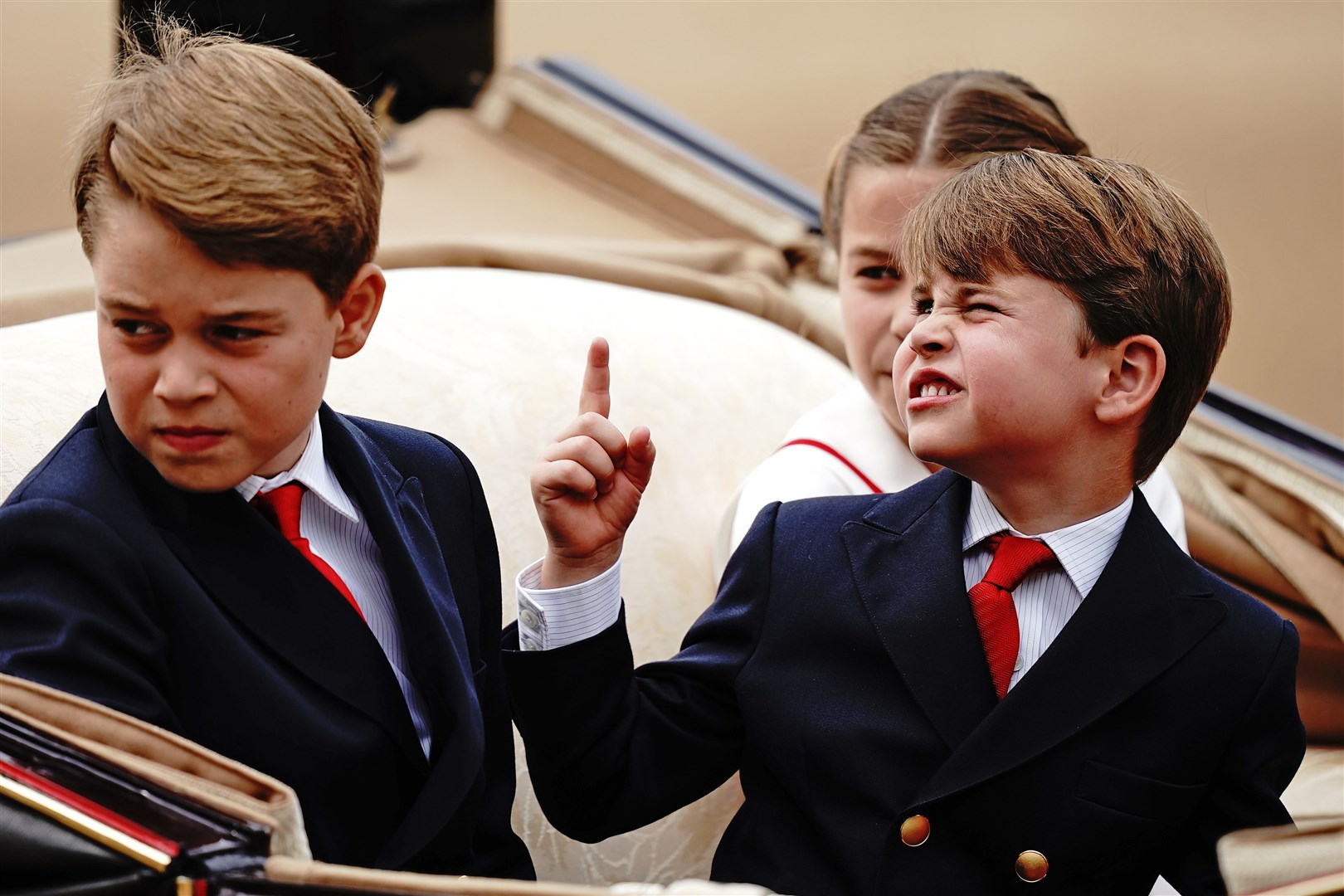 From left, Prince George, Prince Louis and Princess Charlotte ride in a carriage (Aaron Chown/PA)