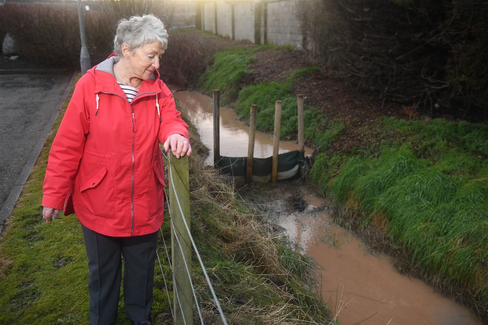 Alison Taylor, local resident, standing next to one of the silt collectors that isn't catching the silt from the work site. Picture: James Mackenzie.