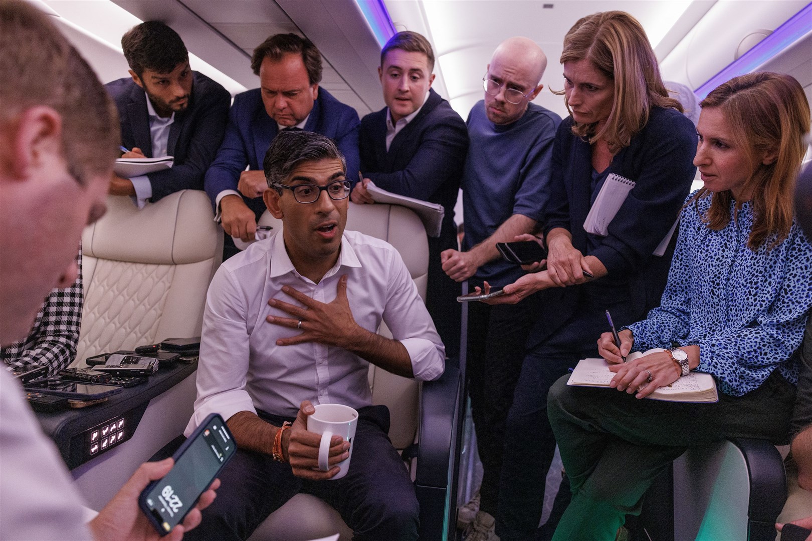 Rishi Sunak holds a ‘huddle’ press conference with political journalists on board a Government plane as he travels to New Delhi (Dan Kitwood/PA)