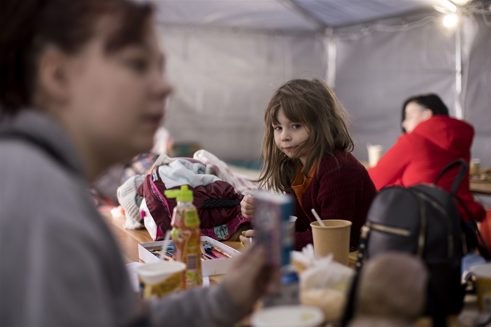 Lilia, six, with her mother Mila at the Caritas tent on the Ukraine/Poland border at Kroscienko (Toby Madden/DEC/PA)