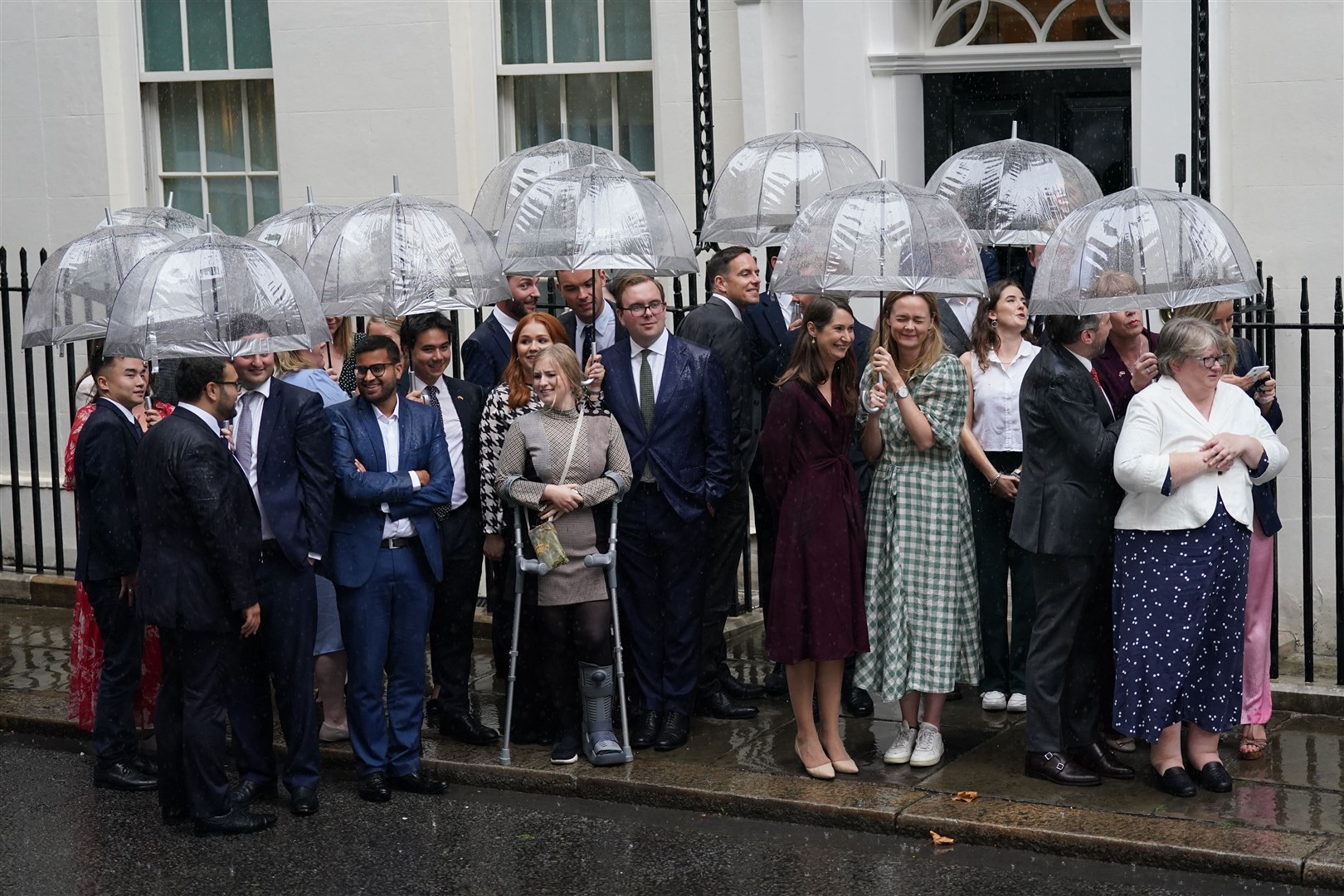 Downing Street staff and supporters gather under umbrellas (Kirsty O’Connor/PA)