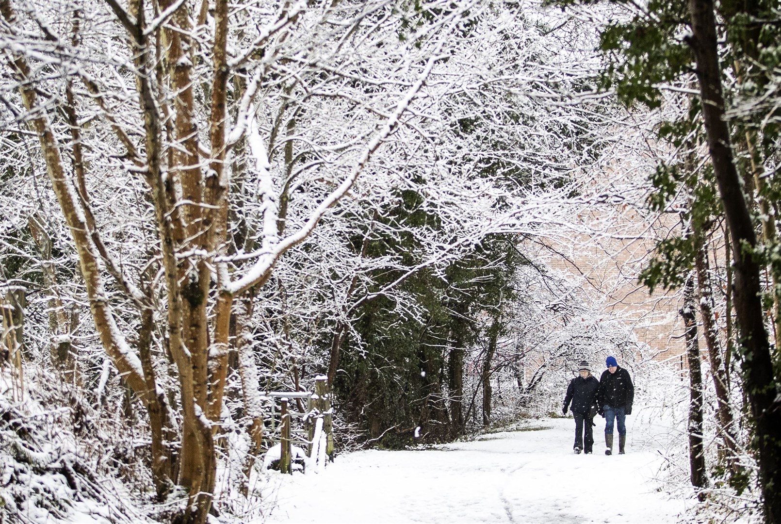 A couple walk through the snow in Auchendinny, Midlothian (Jane Barlow/PA)