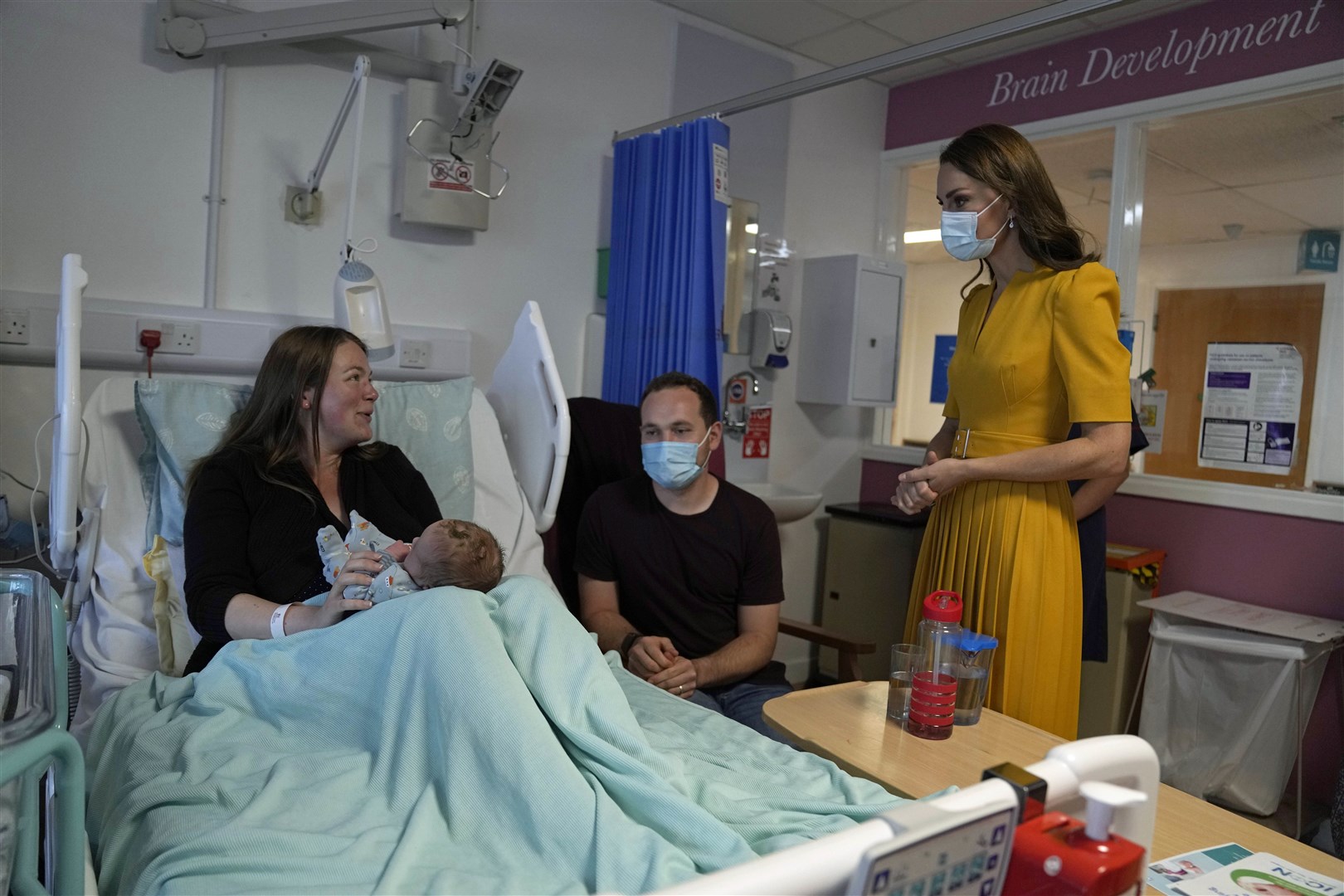 Kate speaks to Andrew and Jessica Kemp with baby Hugo at the Royal Surrey County Hospital’s maternity unit (Alistair Grant/PA)