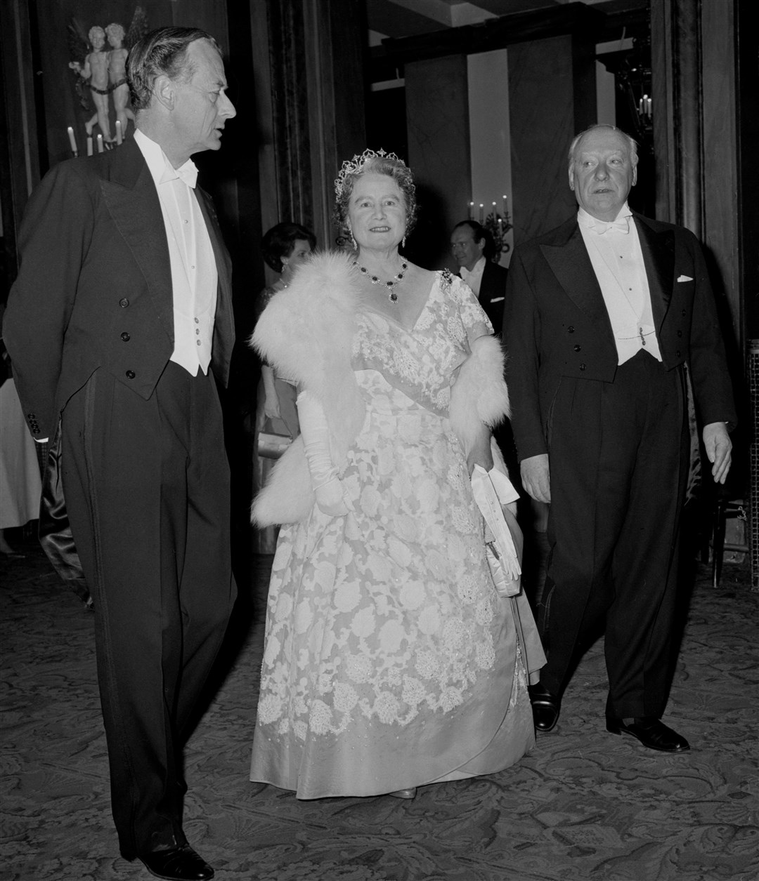 Sir David Webster (right) and the Earl of Drogheda (left) escort the Queen Mother to the Royal Box at the Royal Opera House (PA)
