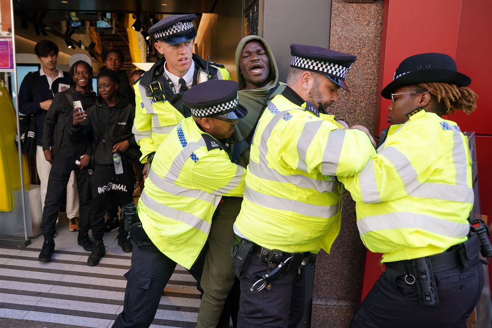 Police officers detain a man outside McDonald’s on Oxford Street (Jonathan Brady/PA)