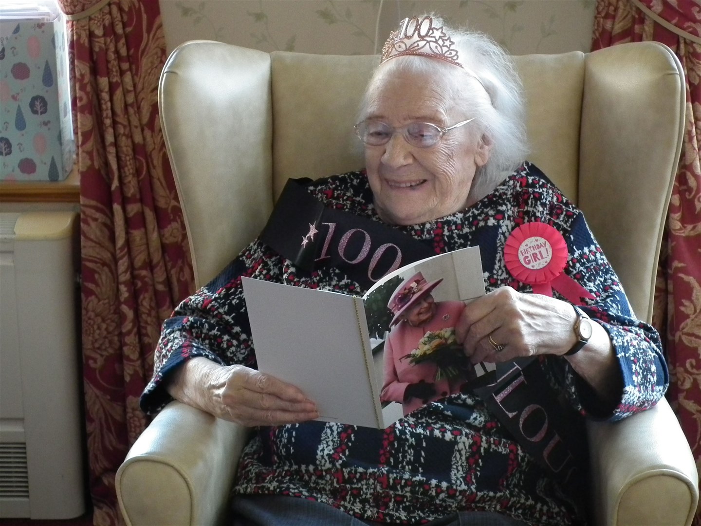 Avis Eckersley takes a look at her card from Queen marking her 100th birthday.