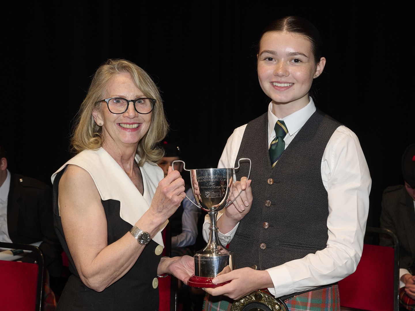 Grace Kelman being awarded the Gordon and Ena Baxter Foundation Cup for Best Junior Piper in the Highlands and Moray.
