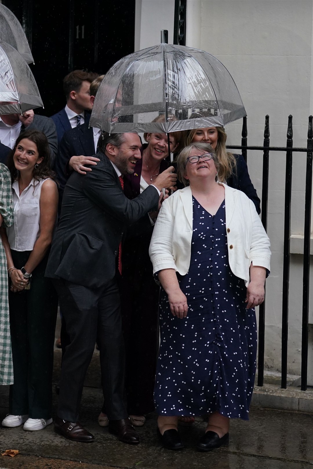 Therese Coffey sheltering from the rain in Downing Street (Kirsty O’Connor/PA)