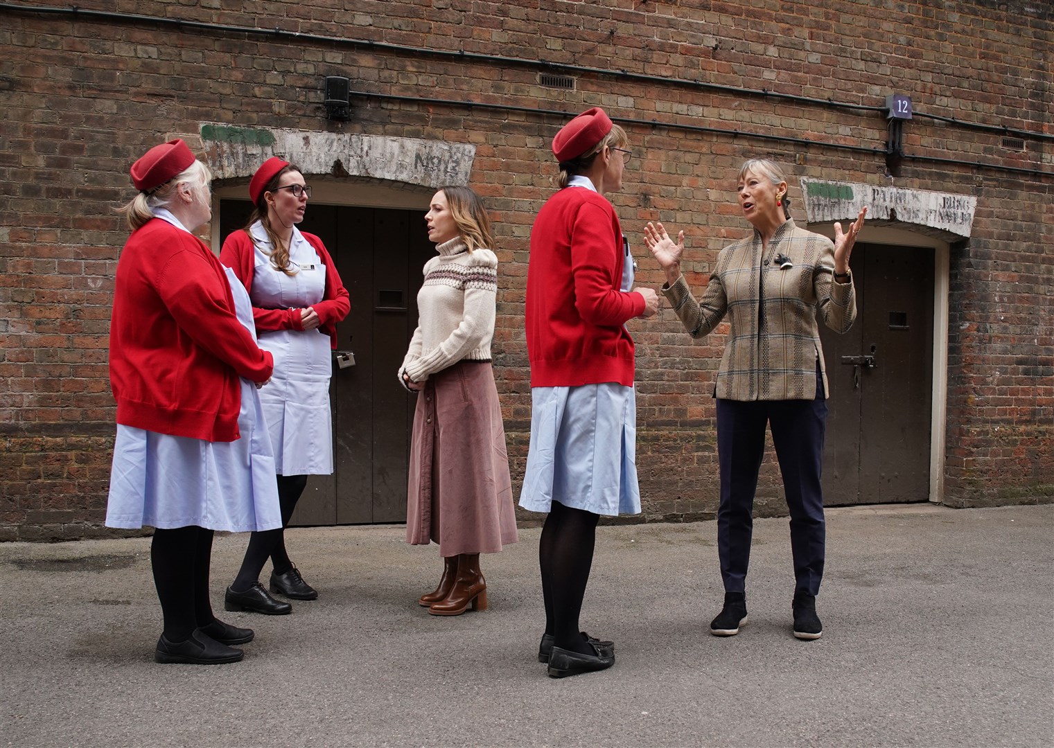 Laura Main and Jenny Agutter talk to tour guides dressed as midwives at the Call The Midwife Official Location Tour at the Historic Dockyard Chatham in Kent (Gareth Fuller/PA)