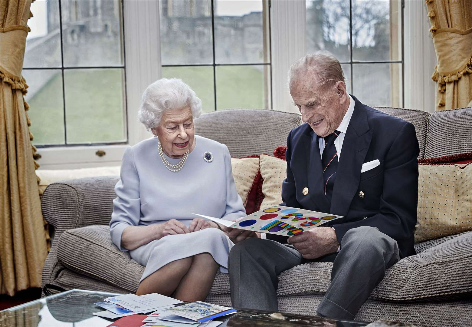The Queen and Philip look at an anniversary card made by the Cambridge children (Chris Jackson/PA)