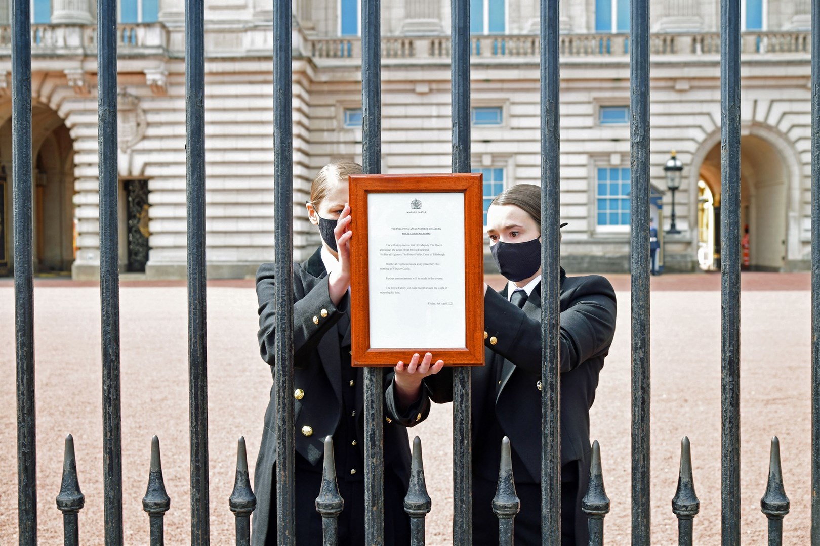 A sign announcing the death of the Duke of Edinburgh, who has died at the age of 99, is placed on the gates of Buckingham Palace (Ian West/PA)