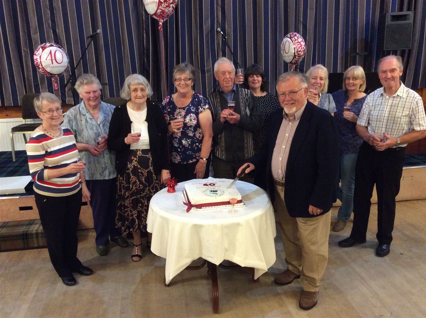 Dingwall & District Accordion & Fiddle Club's chairman Hamish MacLennan cuts a cake to celebrate the group's 40th anniversary at The National Hotel.