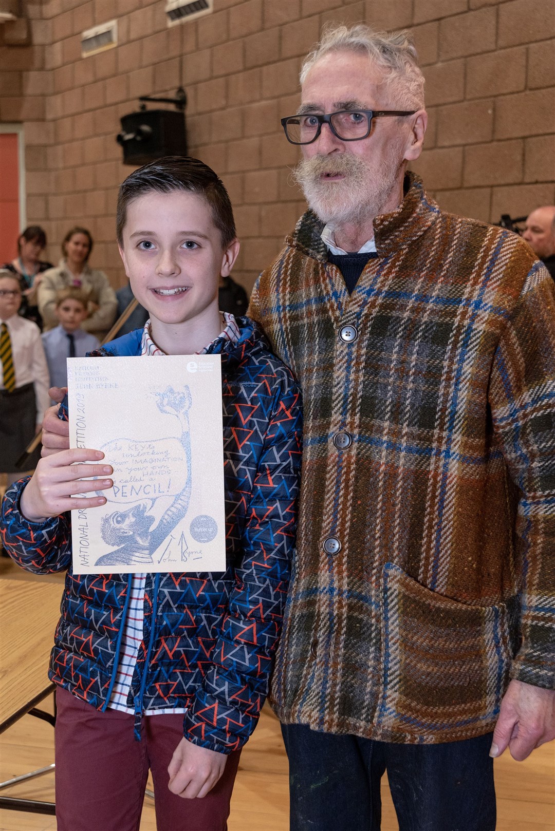 John Byrne presents Kai Finlayson of Strathpeffer Primary School with a runner-up award.