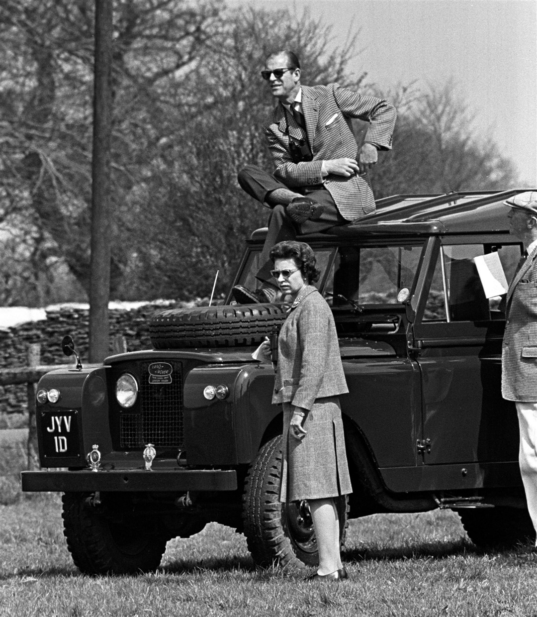 The Duke of Edinburgh, perches on the roof of a Land Rover while the Queen watches competitors during the Horse Trials at Badminton (PA)
