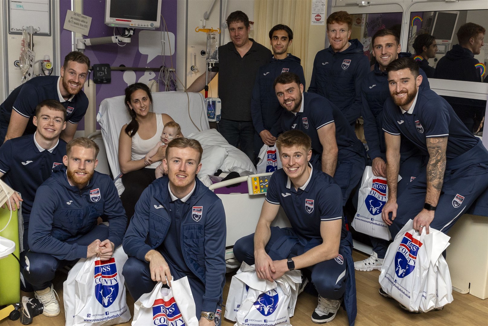 (from left to right) Jay Henderson, Jordan White, Josh Sims, Kyle Turner, Max Sheaf, Yan Dhanda, Connor Randall, Simon Murray, Ben Purrington and Jack Baldwin pictured with a patient in the Highland Children’s Unit and her mother. Picture: Ken Macpherson