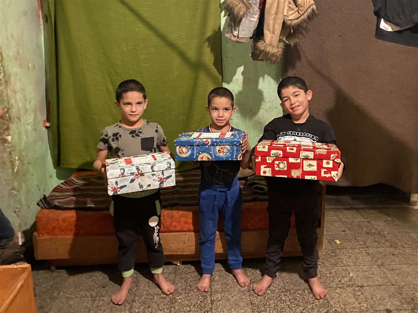 Brothers Rikardo, Jozsef and Zoltan, with boxes distributed to low-income families in Ozd, northern Hungary