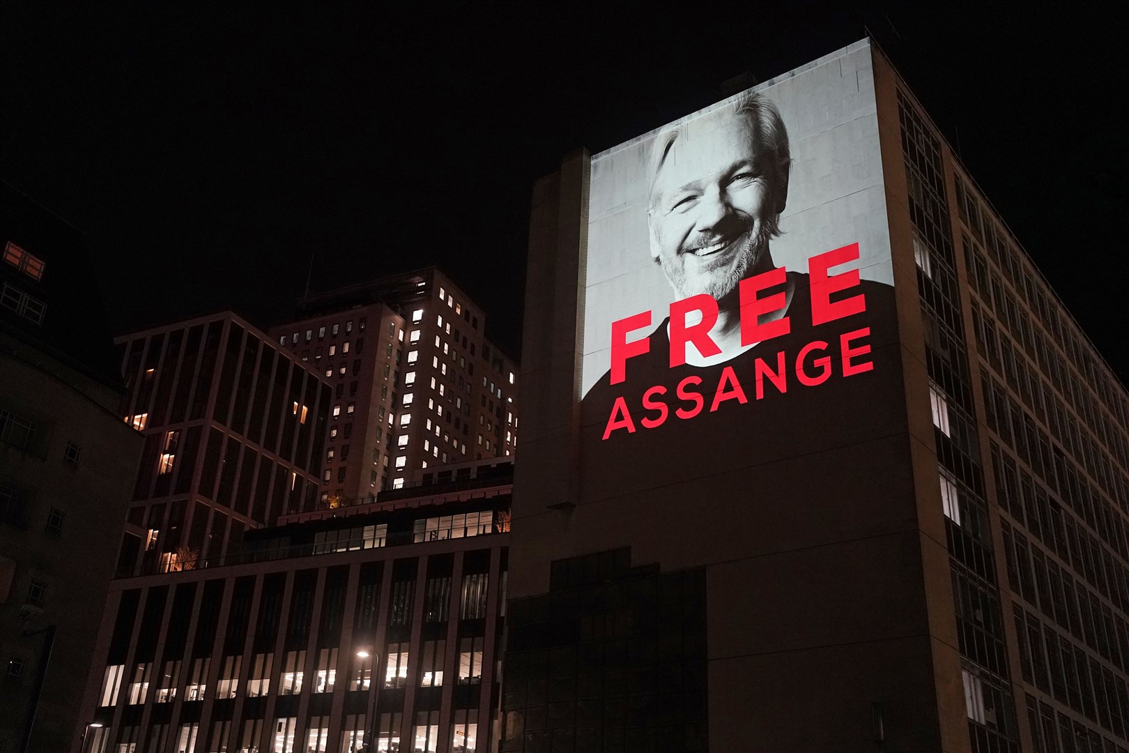 An image of Julian Assange is projected on to a building in Leake Street in central London to mark three years since his arrest and detention in Belmarsh Prison while the United States continues with legal moves to extradite him (Victoria Jones/PA)