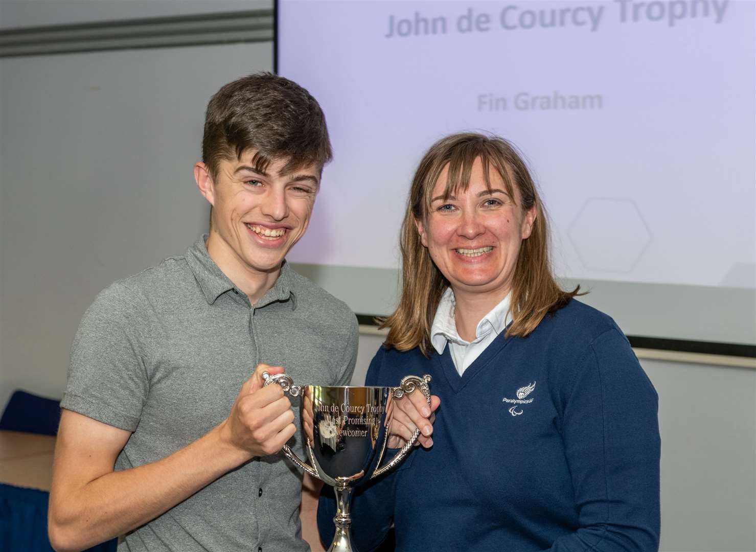 Fin Graham received the John de Courcy Trophy from Sheila Swan, head coach of the Scottish and Great Britain Wheelchair Curling Team.