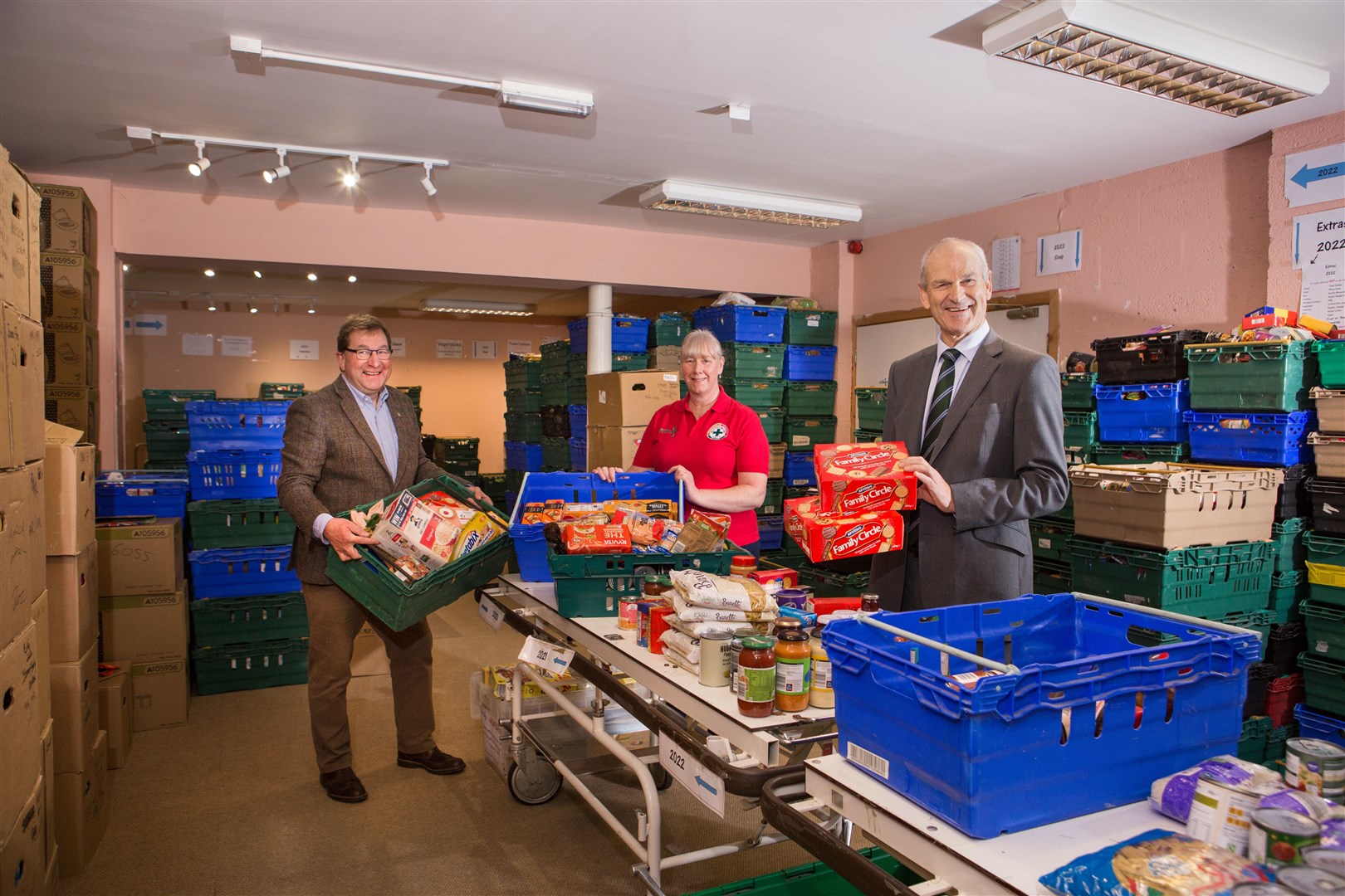 George Fraser (left) helps James Campbell and manager Lorna Dempster with the food parcel packing.