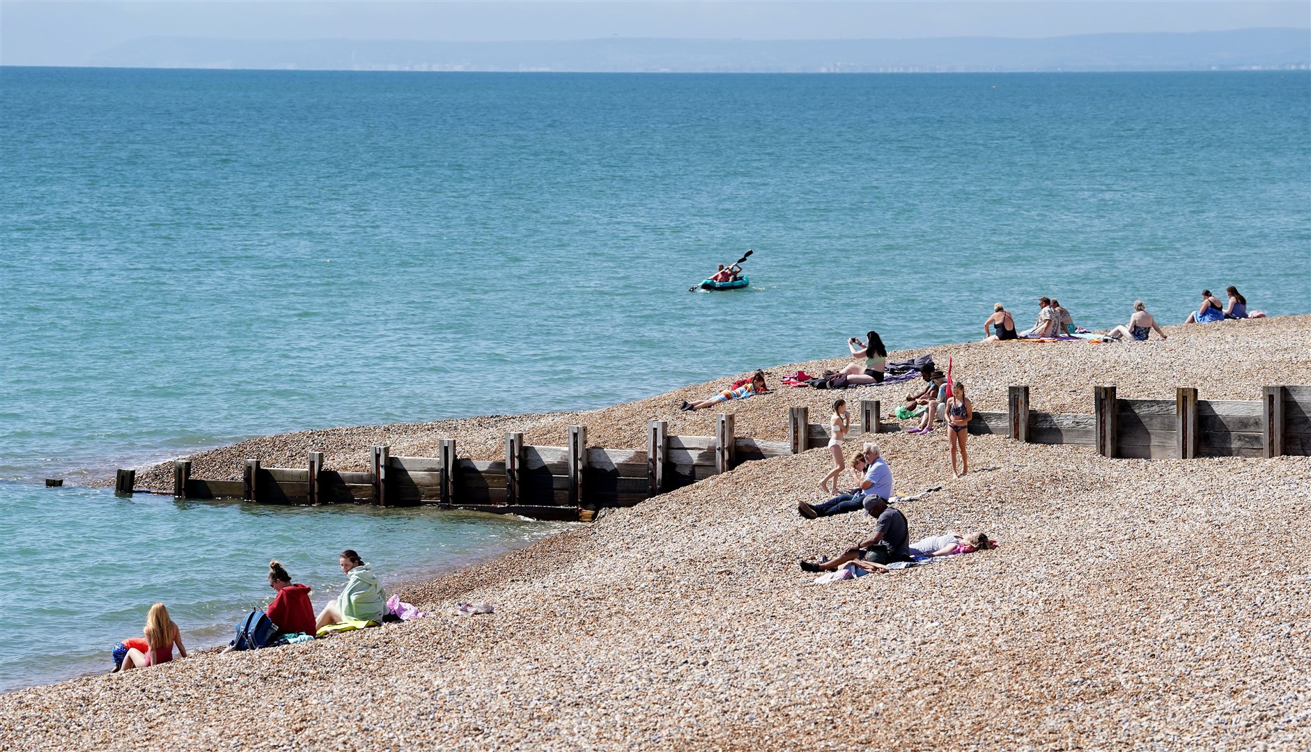 People enjoy the warm weather on the beach (Gareth Fuller/PA)