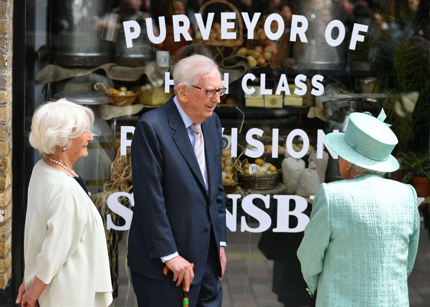 Queen Elizabeth II talks to Lord Sainsbury and his wife outside a replica of one of the original Sainsbury’s stores at Covent Garden, London (Dominic Lipinski/PA Archive)