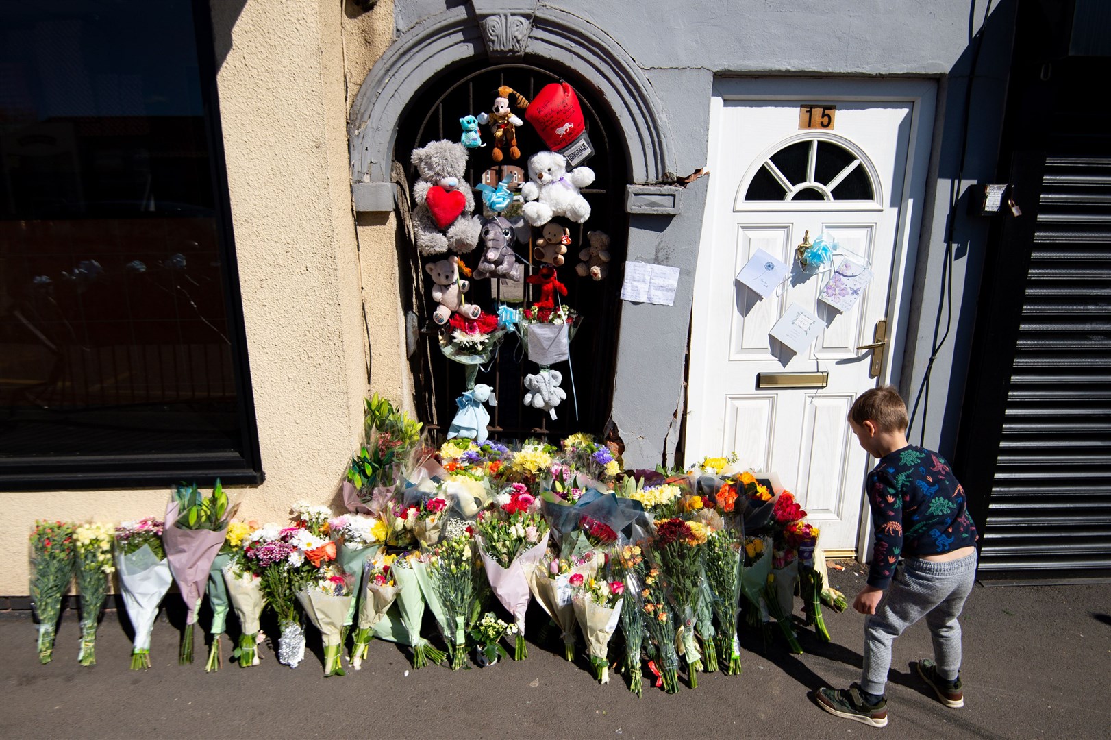 A boy lays flowers at the scene (Jacob King/PA)