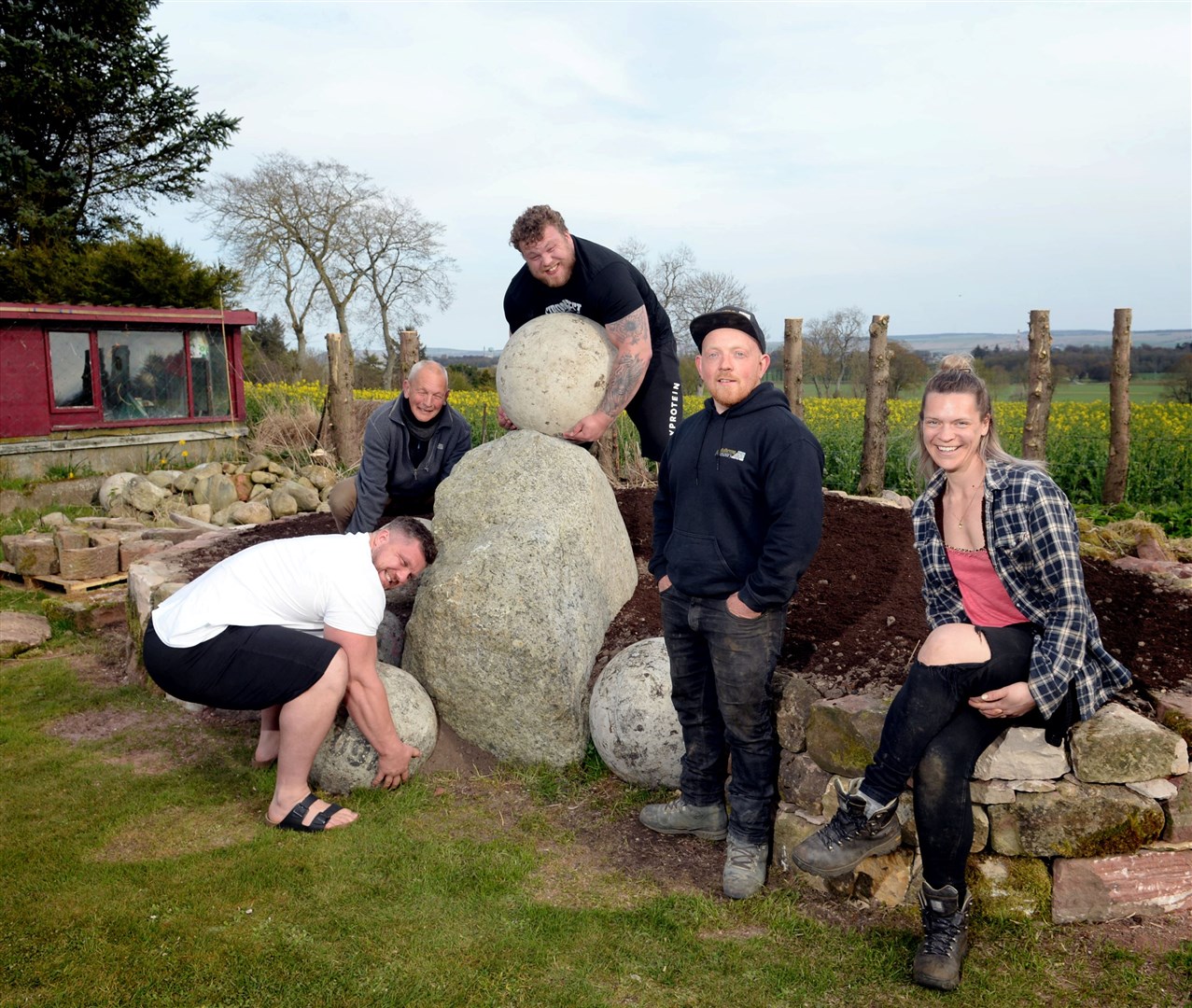 Luke, Ben and Tom Stoltman, Craig Mulheron of Mulheron Masonry and Nikki Stoltman with the Atlas Stones that have been incorporated into the wall around the flower bed. Picture: James Mackenzie
