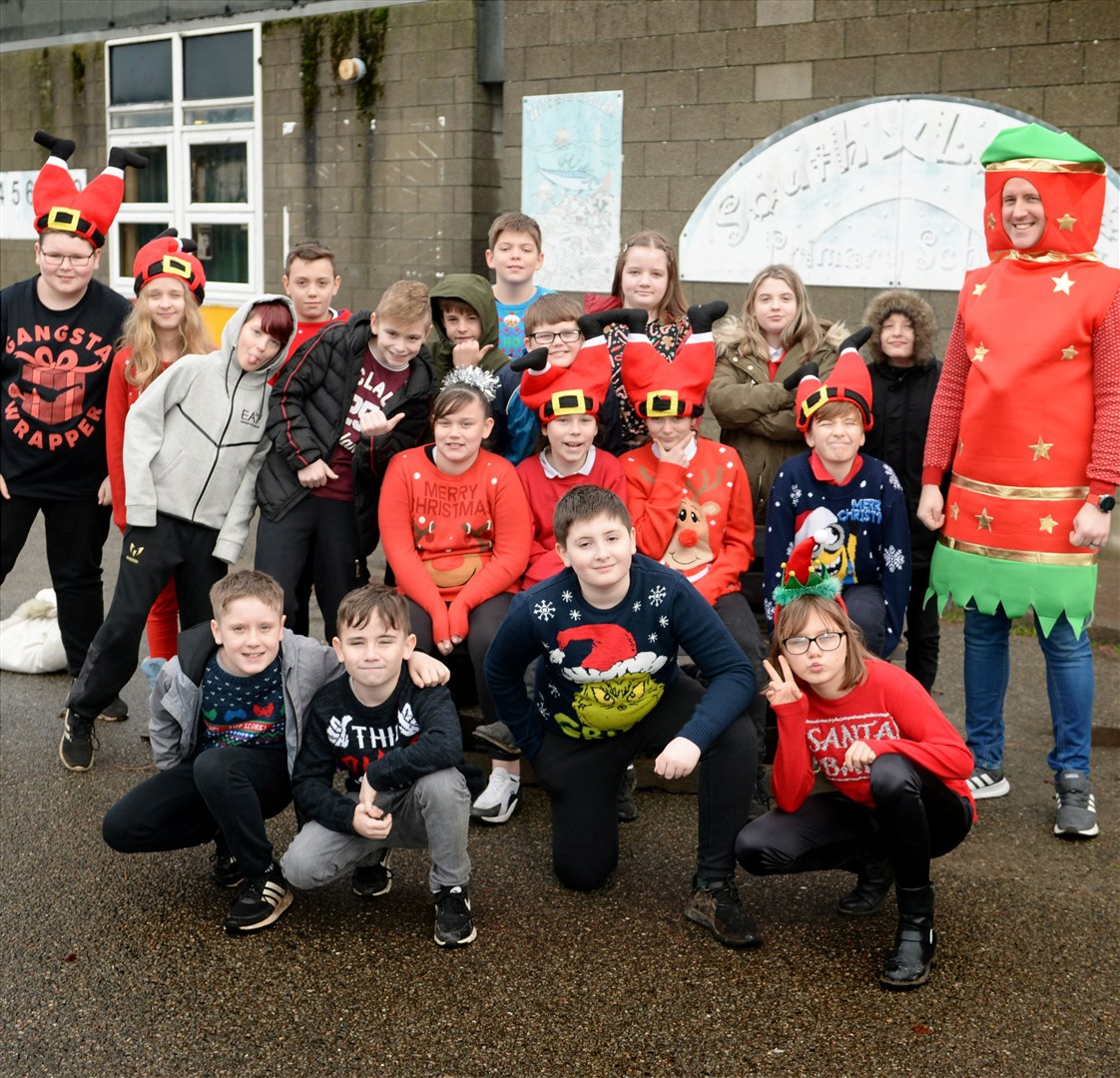 South Lodge Primary Christmas jumper day..Head teacher David Hayes-Macleod dressed as a cracker posing with his P7 pupils..Picture: James MacKenzie..